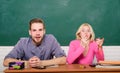 Guy and girl sit at desk in classroom. Wondering about result. Studying in college or university. Couple friends Royalty Free Stock Photo