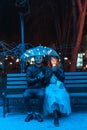 Guy and girl sitting on a bench under an umbrella Royalty Free Stock Photo