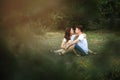 A guy and a girl are sitting on the grass and looking at each other in the park Royalty Free Stock Photo