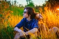 Guy and the girl sitting in the grass on a sunset background Royalty Free Stock Photo