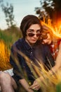 Guy and the girl sitting in the grass on a sunset background Royalty Free Stock Photo