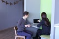 Guy and girl students relax in library after school and sit at t