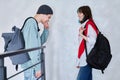 Guy and girl, teenage students with backpacks, standing talking indoors Royalty Free Stock Photo