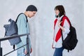 Guy and girl, teenage students with backpacks, standing talking indoors Royalty Free Stock Photo