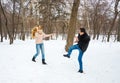 The guy and the girl throw snowballs at each other in the winter outside Royalty Free Stock Photo