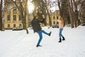 The guy and the girl throw snowballs at each other in the winter outside Royalty Free Stock Photo