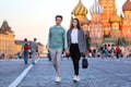 A guy and a girl walk holding hands on Red Square against