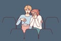 Guy and girl are watching horror movie in cinema and eating popcorn enjoying films about vampires