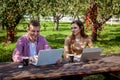 A guy with a girl working on laptops in the park Royalty Free Stock Photo