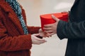 A guy gives his girlfriend a heart-shaped box close up in Valentine& x27;s Day. Young couple at shopping mall.