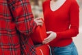 A guy gives his girlfriend a heart-shaped box in Valentine& x27;s Day. Young couple at shopping mall.