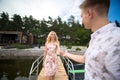 The guy gives his hand to the girl, helps to get into the boat on the pier Royalty Free Stock Photo
