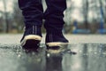 Guy goes in sneakers on the street in the rain