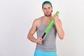 Guy in grey tank top holds bright green bat. Royalty Free Stock Photo