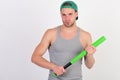 Guy in grey tank top holds bright green bat Royalty Free Stock Photo