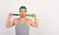 Guy in grey tank top holds bright green bat Royalty Free Stock Photo
