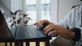 Guy hands typing keyboard laptop at apartment closeup. Man arms pressing buttons Royalty Free Stock Photo