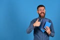 Guy with happy face and books shows thumbs up Royalty Free Stock Photo