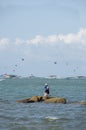 Guy has a quiet moment by himself, fishing on the rock island, Pattaya.