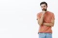 Guy having hesitations, thinking. Portrait of unsure and thoughtful attractive nice bearded guy with dark hair squinting Royalty Free Stock Photo