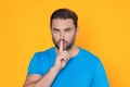 Guy having secret and holding finger on lips. Male model, asks to be quiet. Shh man. Hush shut silent Concept. Mute and Royalty Free Stock Photo