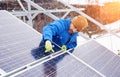 Guy with help of tools installs solar panels, snowy weather Royalty Free Stock Photo
