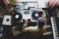 The guy is a hip-hop DJ in a home studio playing records .Hip-hop composer, beatmaker creates rhythms