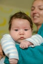 The guy in his arms looks down. A mother holds her newborn baby in her arms, looking at him with a happy look. The boy feels Royalty Free Stock Photo