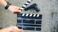 Guy is holding black clapperboard in hands. Man is directing and filming some amateur cinema movie. Detective criminal story. Gun Royalty Free Stock Photo