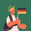 Guy holding Germany flag Oktoberfest party celebration concept man in traditional clothes having fun