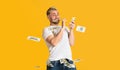 Guy holds banknote in his teeth and scatter money