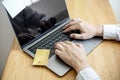 A guy holds a credit card and is filling out his credit card information on his laptop to place an order on the website. Royalty Free Stock Photo