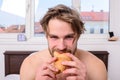 Guy holds croissant bedroom hotel room window background. Enjoy every bite. Man eats croissant he likes bakery products