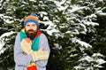 Guy holds cup with firtrees covered with snow on background. Royalty Free Stock Photo