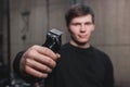 A guy holds an electric shaving machine. Hairdressing