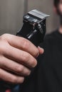 A guy holds an electric shaving machine. Hairdressing