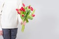 Guy holds flowers. Tulips in the hands of a young man. Flower congratulations for women.Male hands with bouquet of Royalty Free Stock Photo