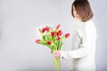 Guy holds flowers. Tulips in the hands of a young man. Flower congratulations for women.Male hands with bouquet of spring flowers Royalty Free Stock Photo