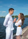 Guy holds the girls hand on a wooden pier near the Royalty Free Stock Photo