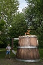 The guy holds a huge wooden mug with beer in the city park Royalty Free Stock Photo