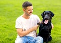 Guy hugging with his dog labrador playing in the park