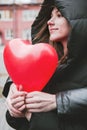 Guy hugs a beautiful young woman holding a red heart-shaped balloon, Valentine`s Day Royalty Free Stock Photo