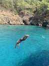 The guy jumps from the deck of the ship into the sea. A man dives into the water from a height. Swimming in the Mediterranean Sea