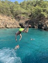 The guy jumps from the deck of the ship into the sea. A man dives into the water from a height. Swimming in the Mediterranean Sea