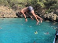 The guy jumps from the deck of the ship into the sea. A man dives into the water from a height. Swimming in the Mediterranean Sea