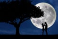 Guy kiss girl hand on full moon silhouette