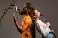 Guy and lady with excited faces enjoy music. Karaoke singer couple. Man and woman singing with music microphone. Royalty Free Stock Photo