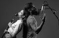 Guy and lady with excited faces enjoy music. Karaoke singer couple. Man and woman singing with music microphone. Royalty Free Stock Photo