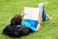Guy laying on the grass and reading a book Royalty Free Stock Photo