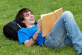 Guy laying on the grass and reading a book Royalty Free Stock Photo